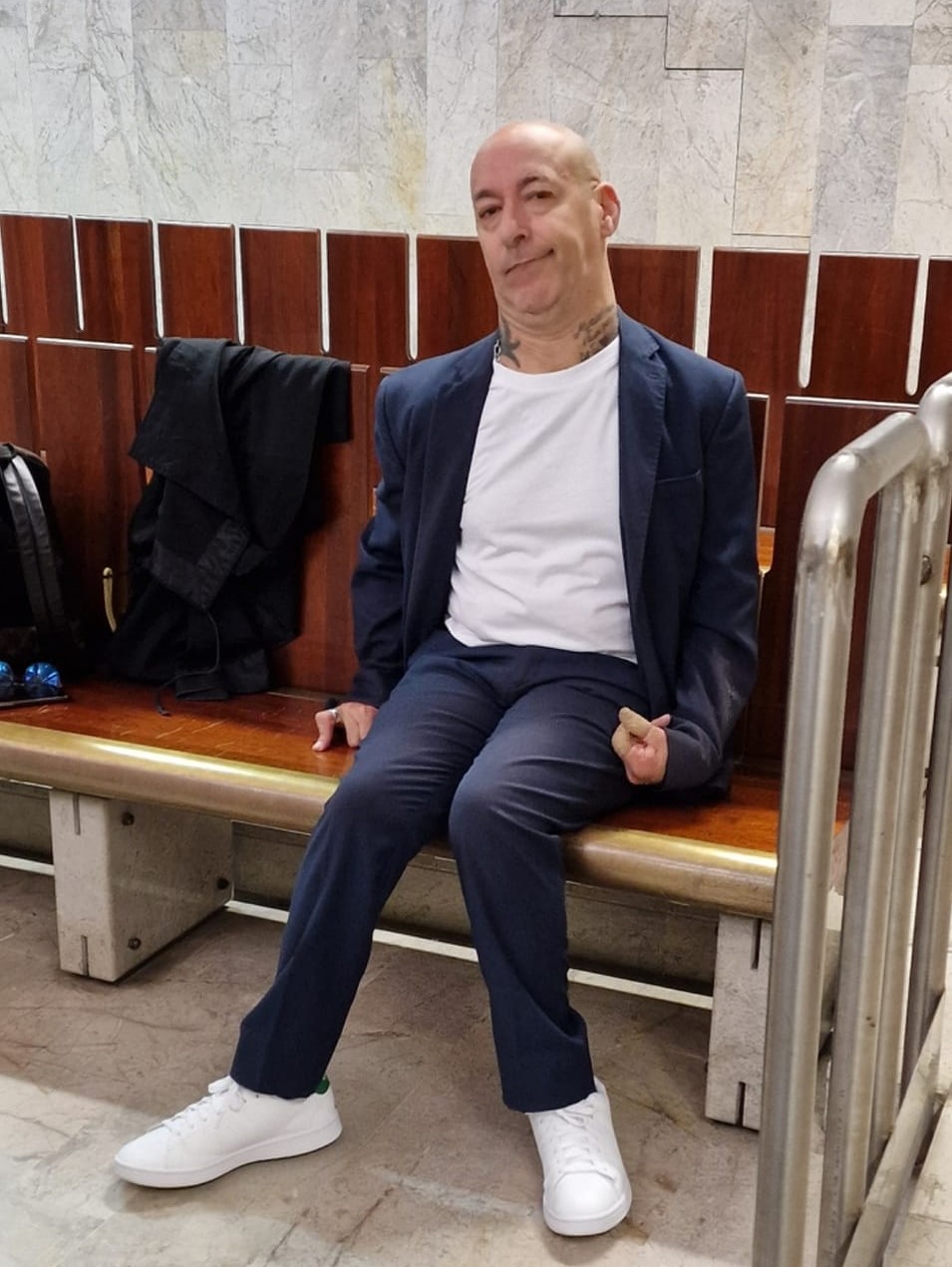 pier seduto in tribunale con tshirt bianca e scarpe da ginnastica bianche